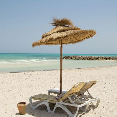 2 transats et parasol sur la plage