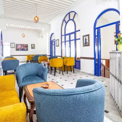 lobby bar de l'hôtel avec 3 grandes portes en arc coloré en bleu assorti aux chaises en bleu et jaune