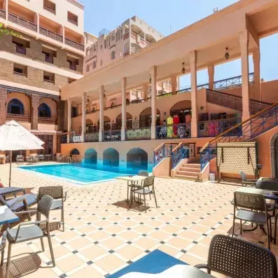 Piscine extérieur de l'hôtel avec des tables et des chaises tout autour