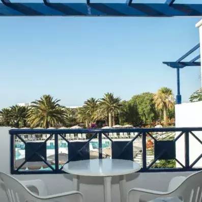 terrasse avec table et chaise vue sur la piscine