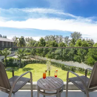 balcon avec deux chaises et une table vue sur le jardin de l'hôtel
