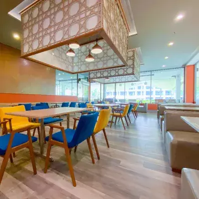 restaurant avec fauteuils et chaises et tables colorées 