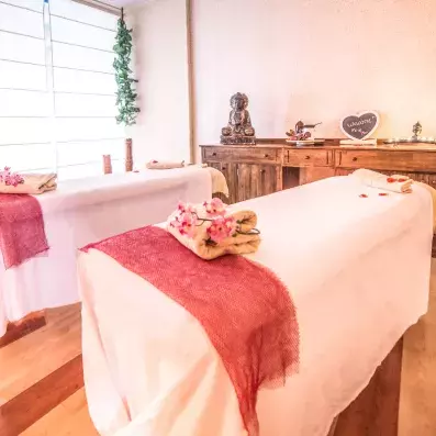 deux tables de massage avec décorations roses et en bois
