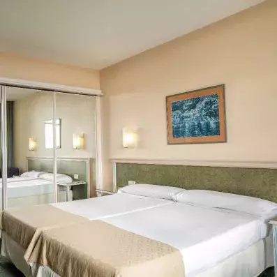 chambre avec deux  lits simples et placard avec miroir