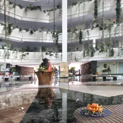 hall d’hôtel lumineux avec balcons en étages et végétation intérieure