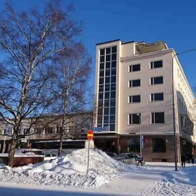 Découvrez la façade enneigée de l'Hôtel Merihovi, parfait pour vos vacances d'hiver en Laponie.