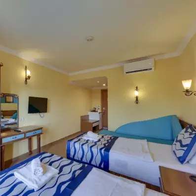 chambre club room avec deux lits simples et une télévision