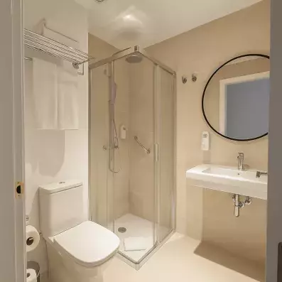 salle de bain avec douche avec toilette et miroir