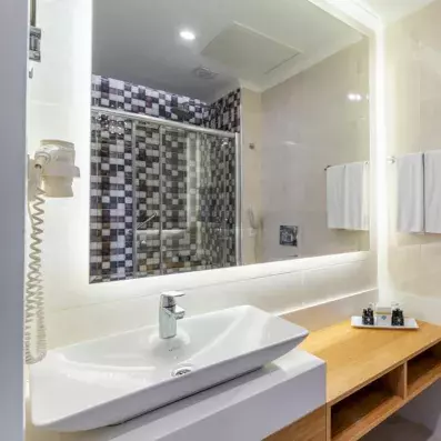 salle de bain en blanc et en bois avec lavabo et miroir