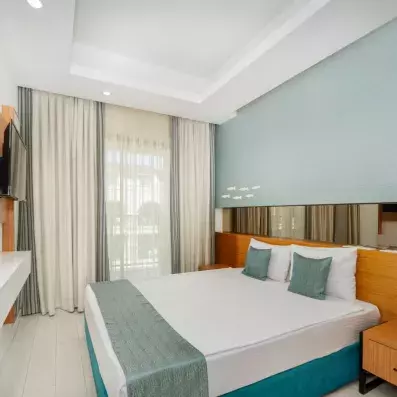 chambre avec un lit double et coussin turquoise