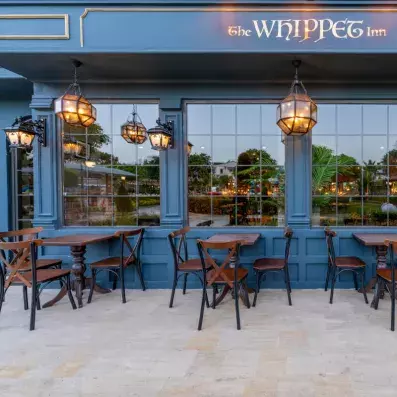 bar extérieur avec tables et chaises en bois foncés