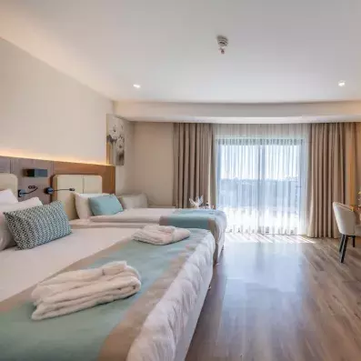 chambre avec un lit double et un lit simple avec une télévision murale