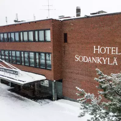 Façade en briques rouges de l'Hôtel Sodankylä sous la neige en Laponie finlandaise.