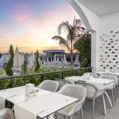 restaurant sur la terrasse vue sur la piscine au coucher du soleil