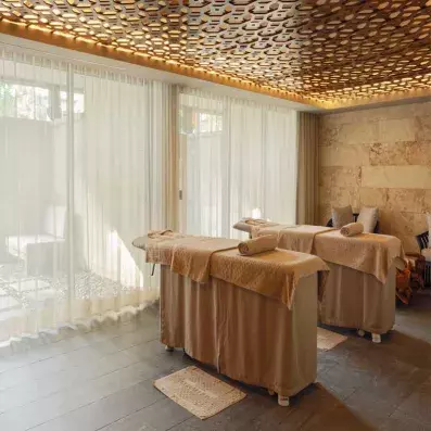 deux tables de massage devant une vitre lumineuse, ambiance zen