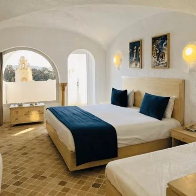 Chambre lumineuse à l'architecture typique, vue sur coupole, hôtel Lella Baya, séjour détente à Hammamet, Tunisie.