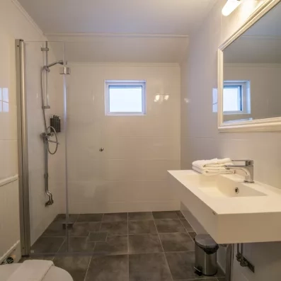 Salle de bain moderne et lumineuse avec douche à l'italienne, confort hôtelier au Grand Arctic Resort.