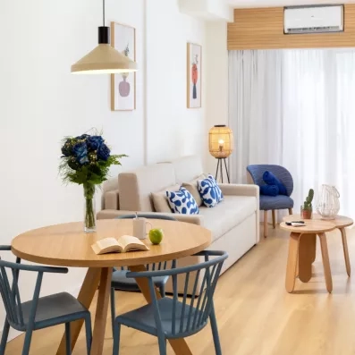 salon avec canapé gris et petite table avec deux chaises bleues