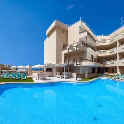 vue d'ensemble sur la piscine avec le bâtiment de l'hôtel en arrière plan 