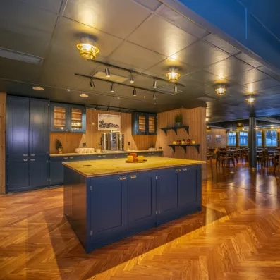 Espace buffet et îlot central en bois massif, salle de restauration chaleureuse pour vos vacances en Suède.