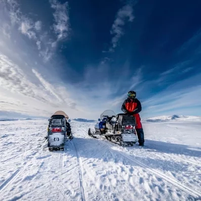 Expédition en motoneige sur les plaines blanches, aventure hivernale intense près de l'Hôtel Matarengi Lodge.