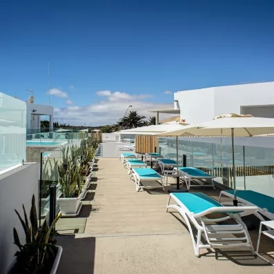 Une solarium ensoleillé accueillant de nombreux transats sous un ciel bleu.