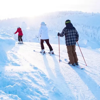 Session de ski alpin en famille sous le soleil arctique, loisirs d'hiver au Grand Arctic Resort.