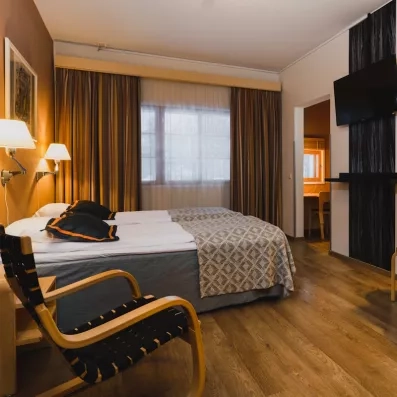 chambre familiale de l'hôtel Levi Spa avec télévision fauteuil et lit double en laponie finlandaise