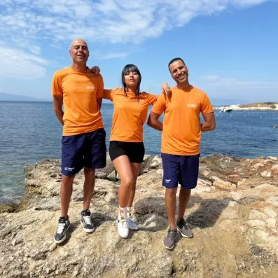 Trois animateurs qui posent sur un rocher vue sur la mer.