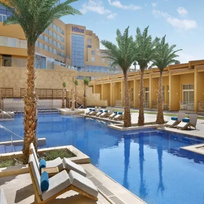 Piscine extérieure et palmiers de l'hôtel tout compris Hilton Hurghada Plaza 5* pour vos vacances.
