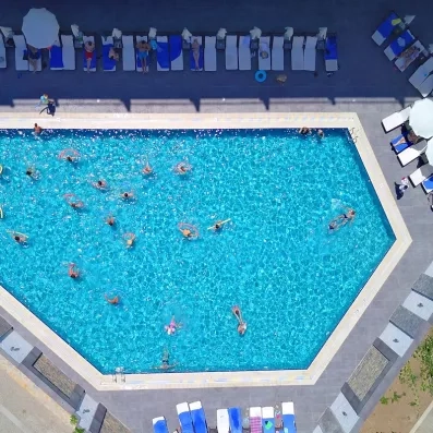 Vue de la grande piscine extérieur avec ses transats et parasols.