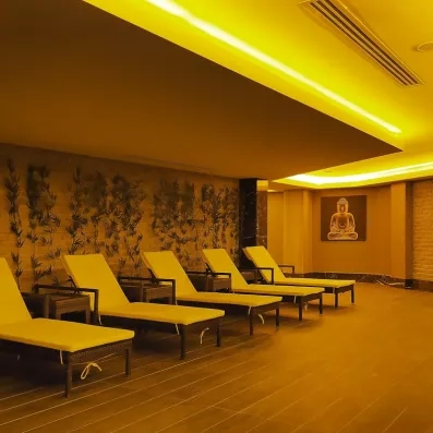 Salle de relaxation avec plusieurs transats alignés et une lumière tamisée.