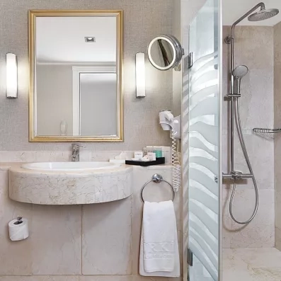 Une salle de bain moderne en marbre avec une douche et un lavabo.