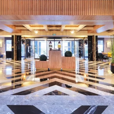 Un grand hall d'entrée luxueux avec un petit comptoir de réception en bois.