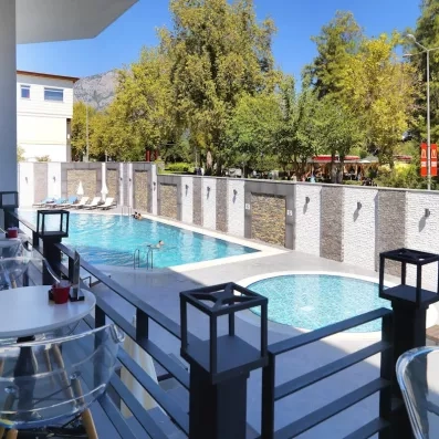 Vue d'une terrasse bordé par une grand piscine et une autre plus petite.