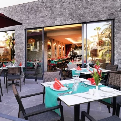 Une terrasse de restaurant acessible par une baies vitrées.
