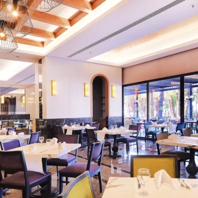 Une salle de restaurant lumineuse grâce a de grandes baies vitrées.