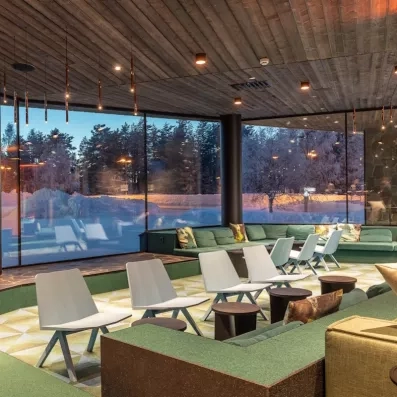 réception moderne de l'hôtel levi spa en laponie finlandaise avec chaises et tables modernes et baies vitrées avec vue panoramique