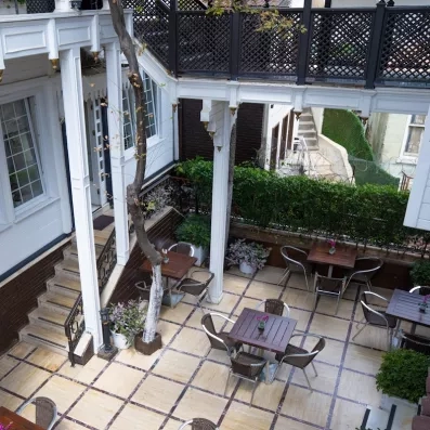 Vue de l'extérieur de l'hôtel sur la terrasse avec des tables 