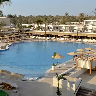 Grande piscine avec transats de l'hôtel Pyramids Park au Caire pour un séjour détente tout compris.