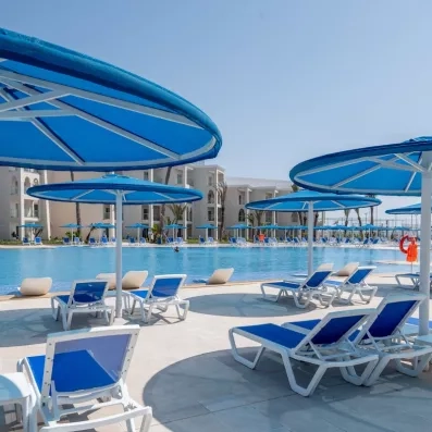 longue piscine transat parasol bleu sol blanc ciel bleu