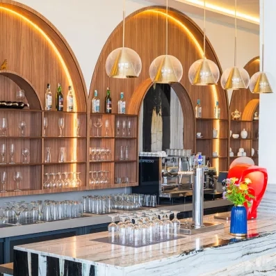 bar gris et fond alcoves en bois lampes rondes verres et bouteilles