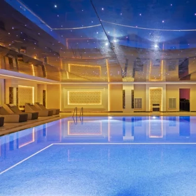 piscine intérieure lumières jaunes et bleue plafond transparant étoilé