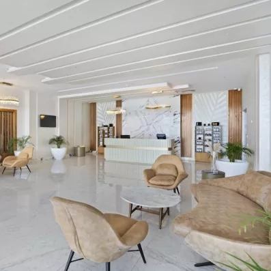 salle reposante couleurs blanc et beige fauteuils et grand canapé