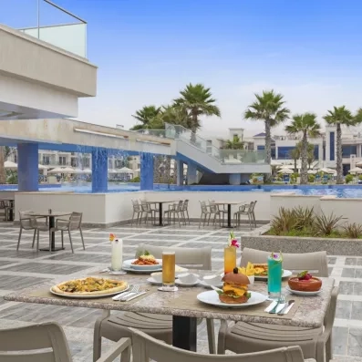 terrasse extérieure table déjeuner burger pizza plats cocktails piscine palmiers