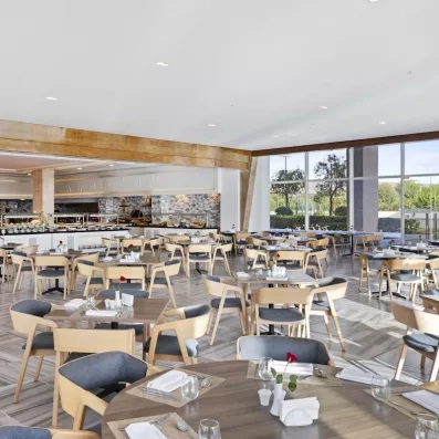 restaurant intérieur chaises marron claires et grises roses sur table