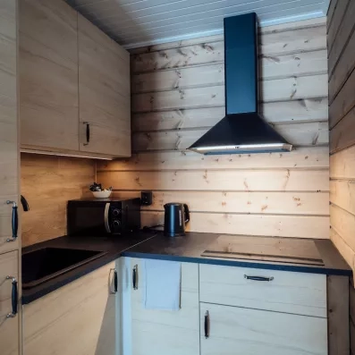 Kitchenette moderne en bois dans un chalet de l'hôtel Grand Arctic en Laponie suédoise.