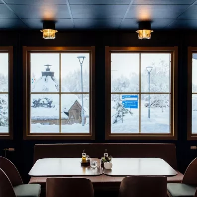 Salle du restaurant du Matarengi Lodge avec vue sur la neige en Laponie suédoise