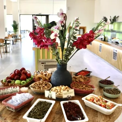 Une table ronde au centre de la salle avec un buffet servie dessus.