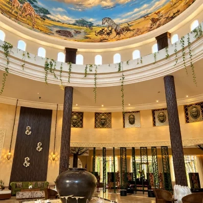 Hall majestueux avec coupole peinte, colonnes décoratives et vaste espace lumineux